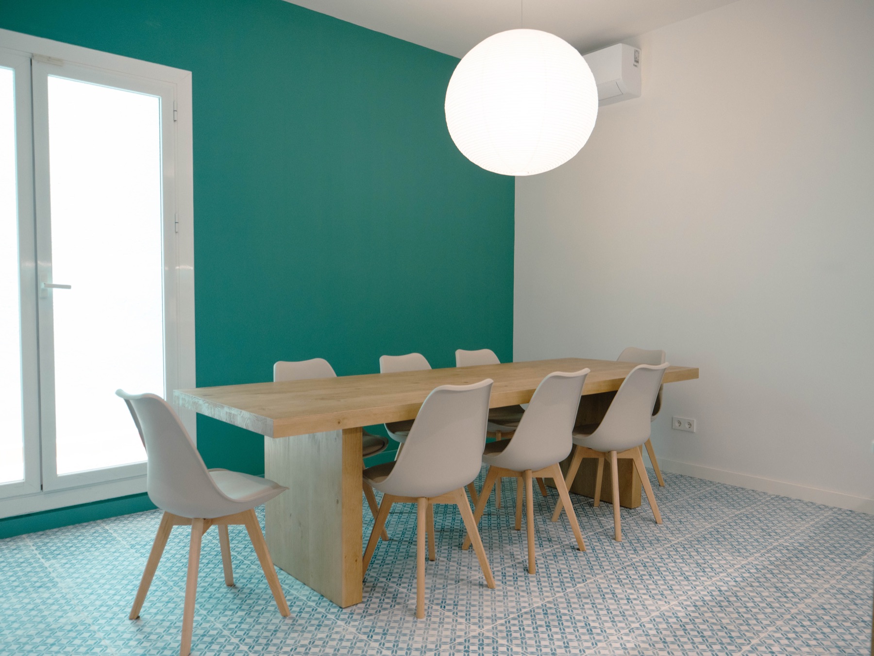 Zona de menjador de la cuina-office de B58, amb taula de fusta i paret teal