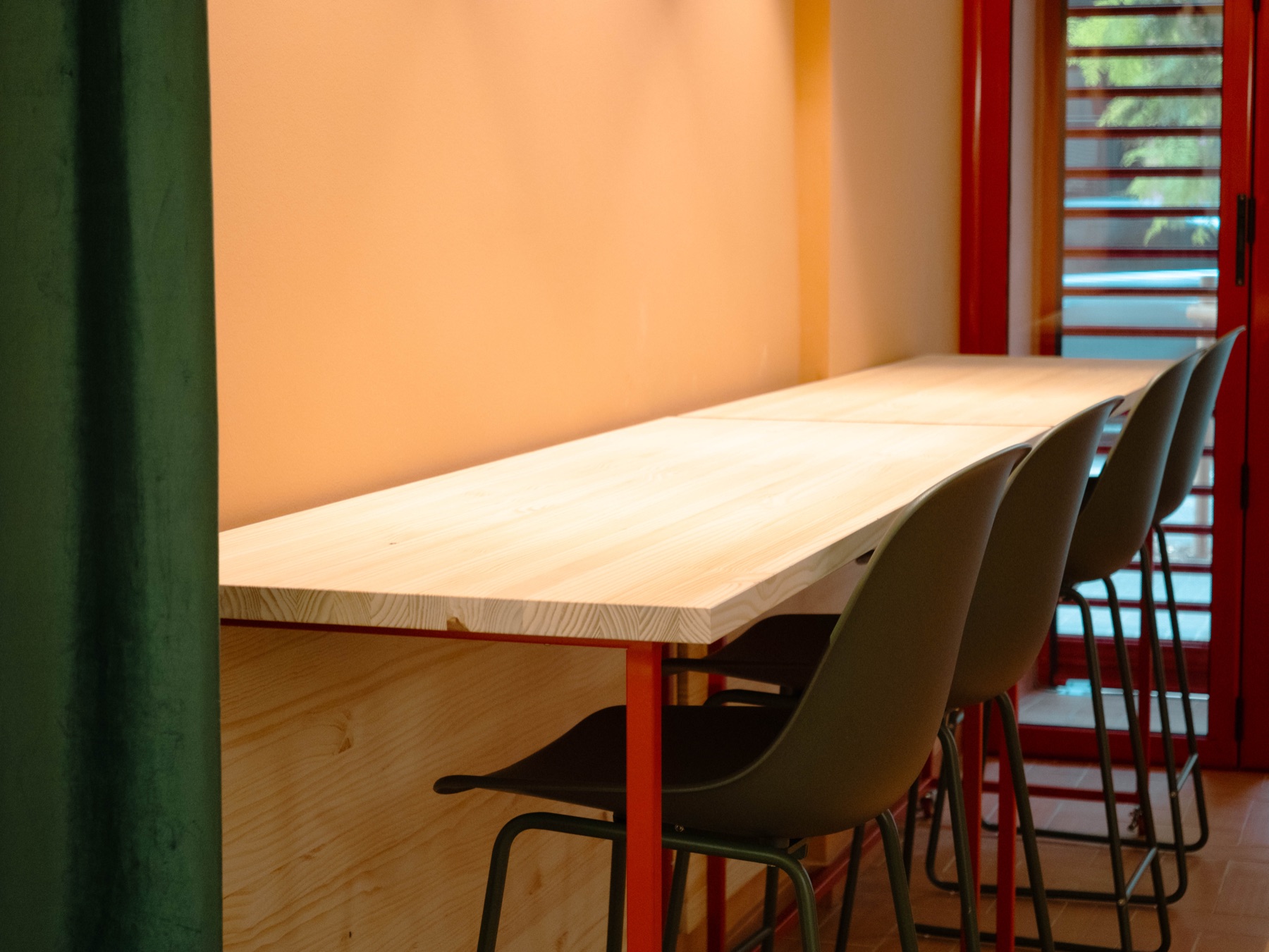 Zona de Coworking Express amb barra alta i tamborets vora el finestral vermell de B58