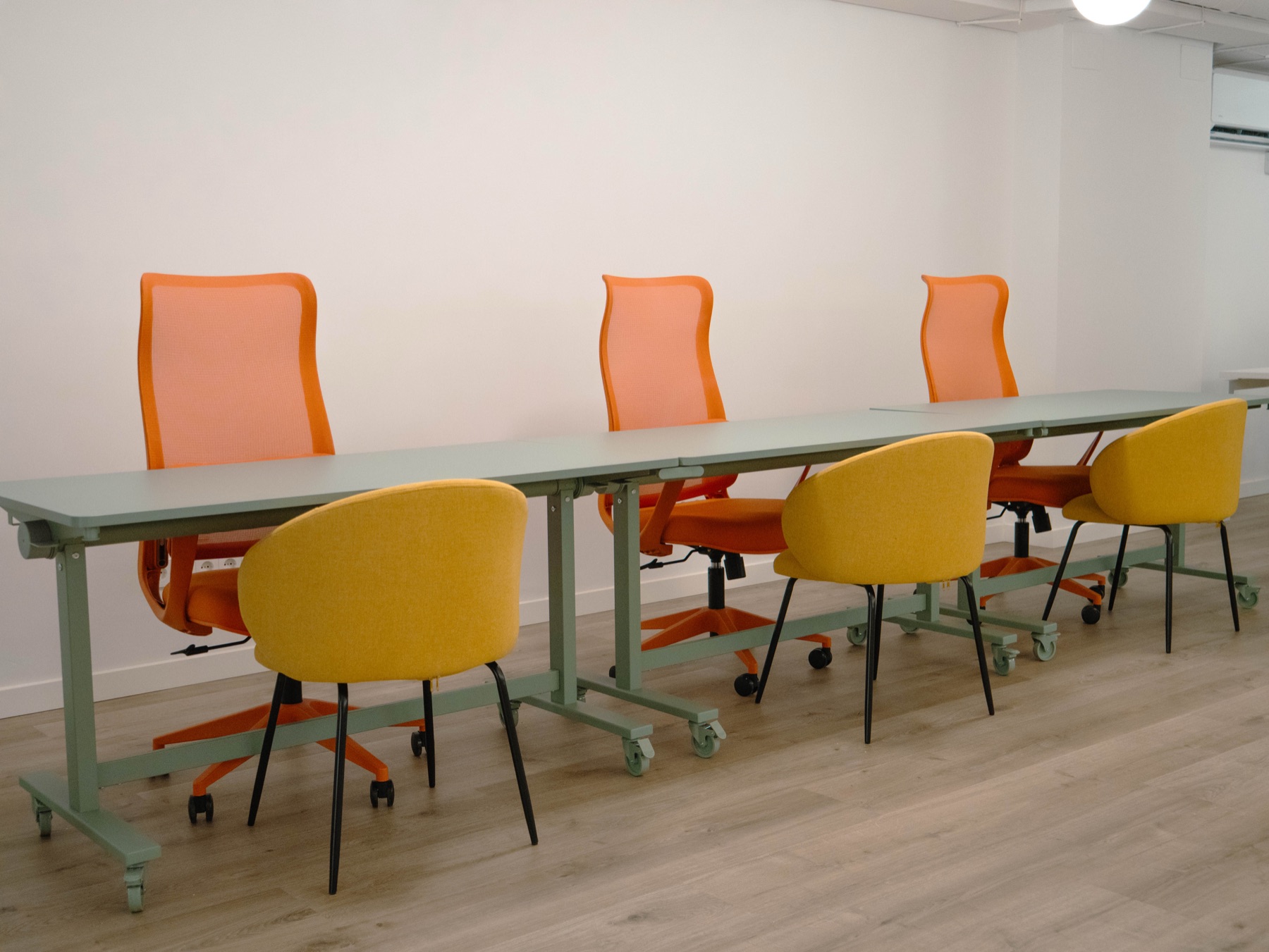Zona flexible de B58 amb taules i cadires de colors taronja i groc